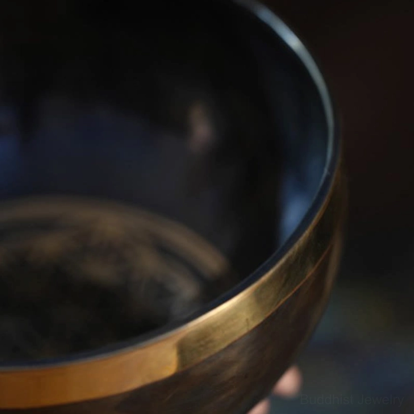 Handmade Buddhist singing bowl with detailed craftsmanship visible in copper patina and artistic etching patterns
