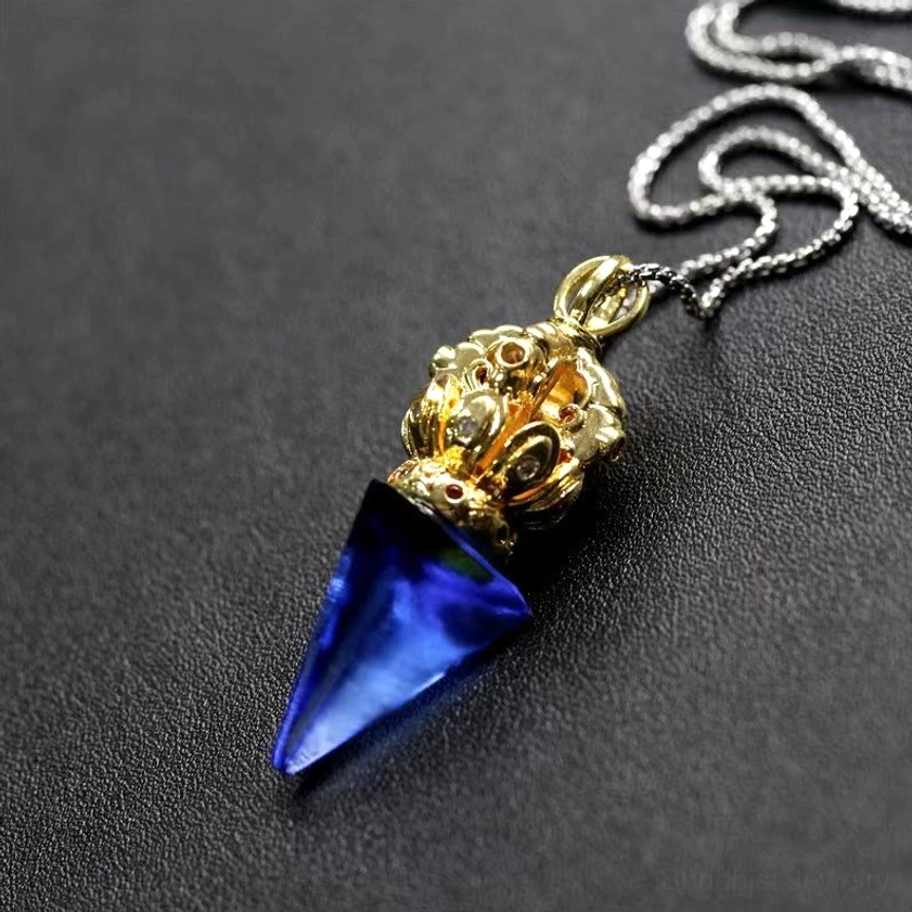 Buddhist Dorje Vajra 4-prong liuli crystal pendant with gold cap and blue crystal on titanium steel chain - three-quarter view