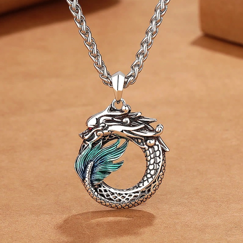 Buddhist dragon copper pendant necklace with bone chain, handmade antique silver finish, top-down close-up view on kraft paper