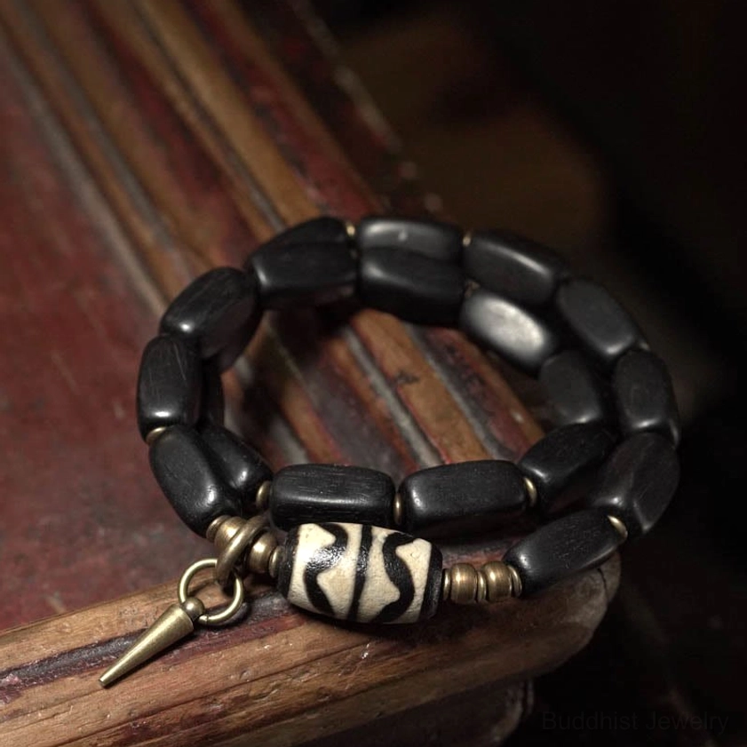 Ebony wood Buddhist dzi bead protection bracelet detail shot with natural lighting