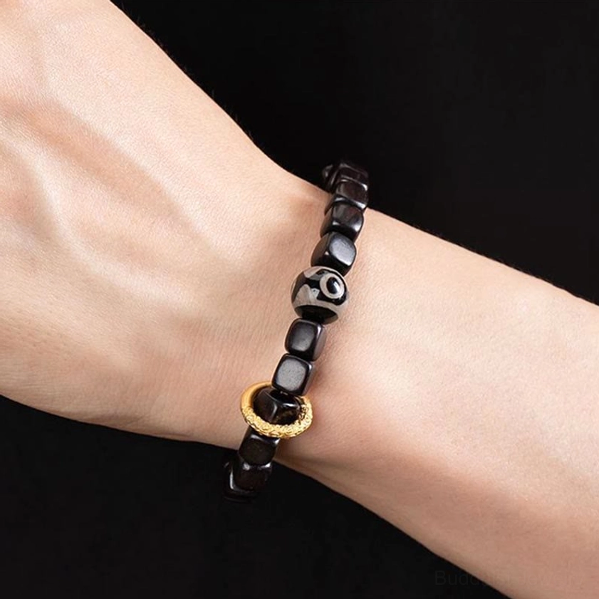 Buddhist ebony wood dzi bead bracelet for meditation and protection, featuring hand-painted nine-eye dzi bead with copper accents