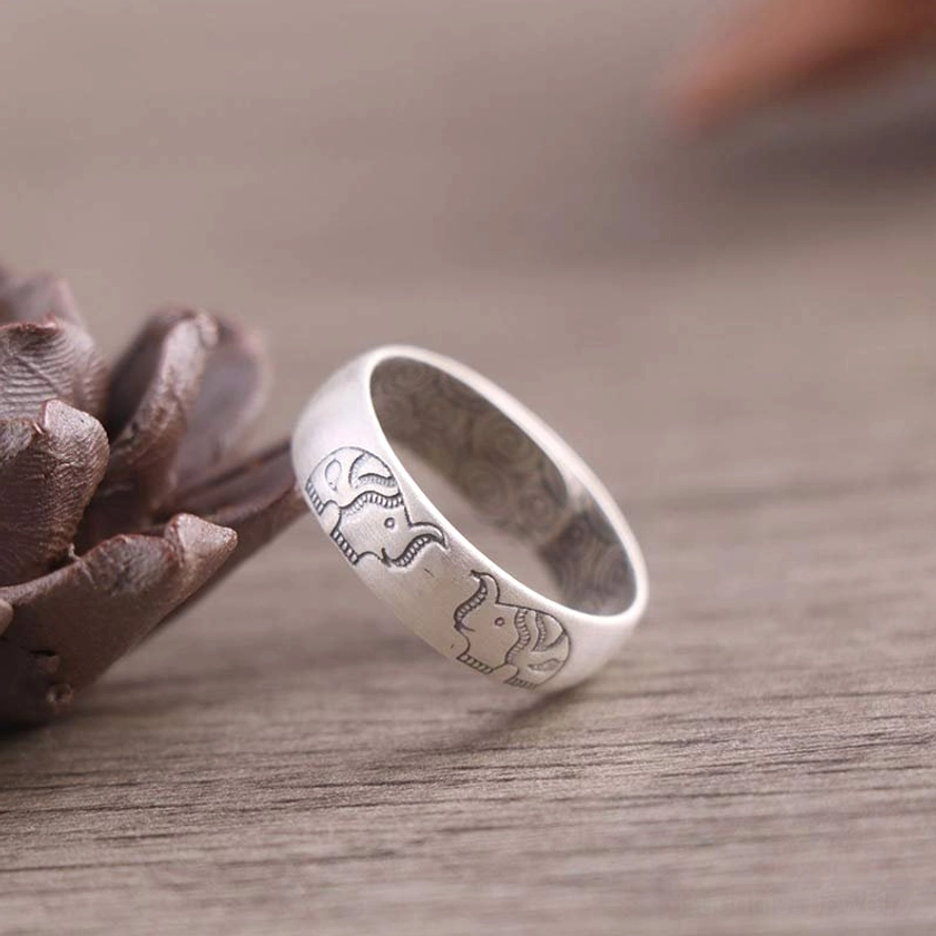 Handmade elephant motif silver ring with Buddhist engraving displayed on dried lotus ornament