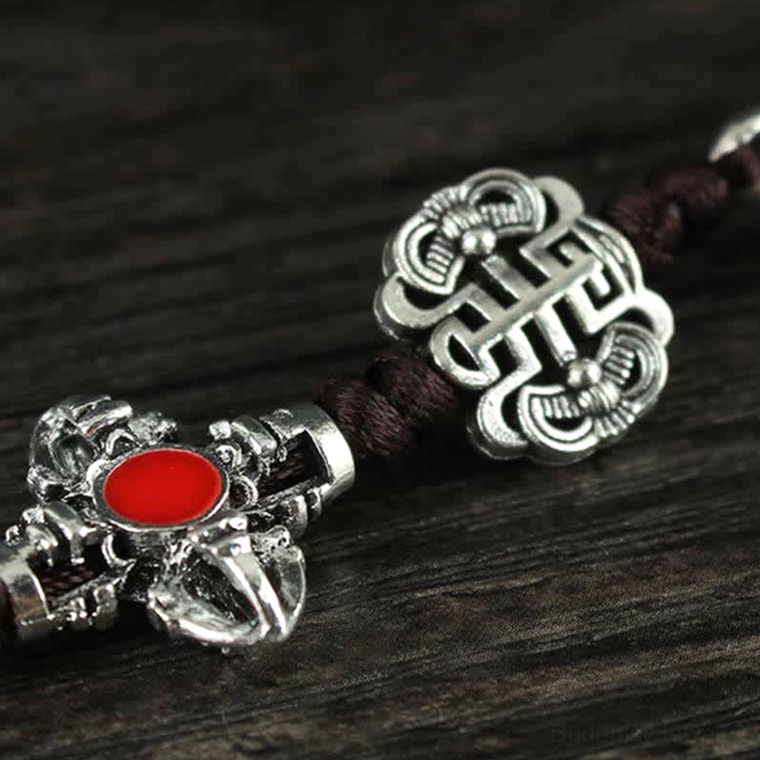 Buddhist endless knot charm with silver tone metal and red stone inlay paired with cross Vajra symbol