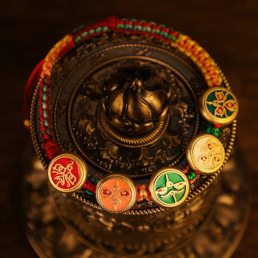 Complete five-piece Buddhist prosperity charm set with braided cord accents displayed on antique brass vessel