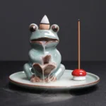 Handcrafted Buddhist frog backflow incense burner in celadon green ceramic with lotus design, frontal view showing ceramic texture and brown glazed details