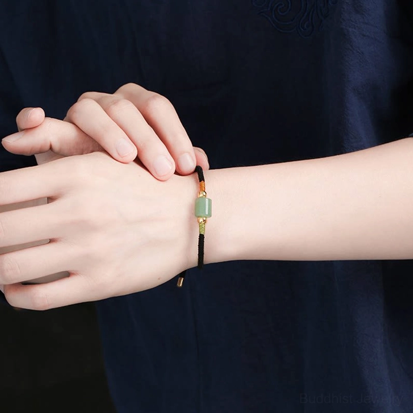 Buddhist red string bracelet with green aventurine gemstone showing natural stone texture and handcrafted braided cord