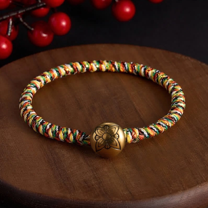 Buddhist handwoven balance bracelet with colorful cord and decorative copper charm bead display