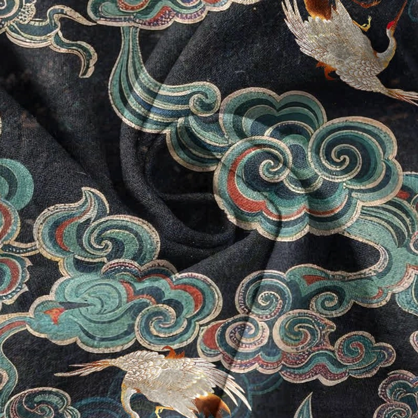 Detailed view of traditional cloud crane and lotus embroidered-style print on Buddhist henley