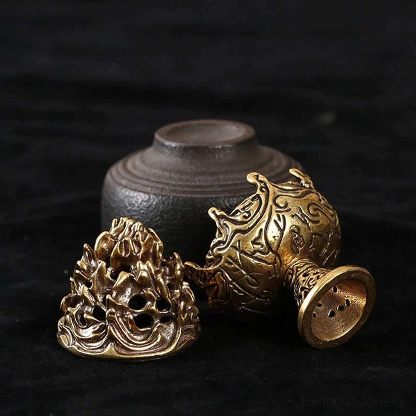 Disassembled handcrafted incense burner set showing antique brass parts with ornate carvings, paired with small ceramic storage jar