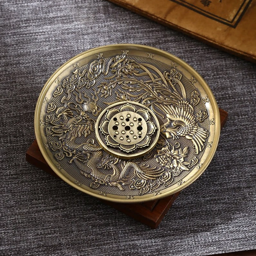 Dragon and phoenix Buddhist incense burner in bronze tone with carved patterns, overhead tabletop view