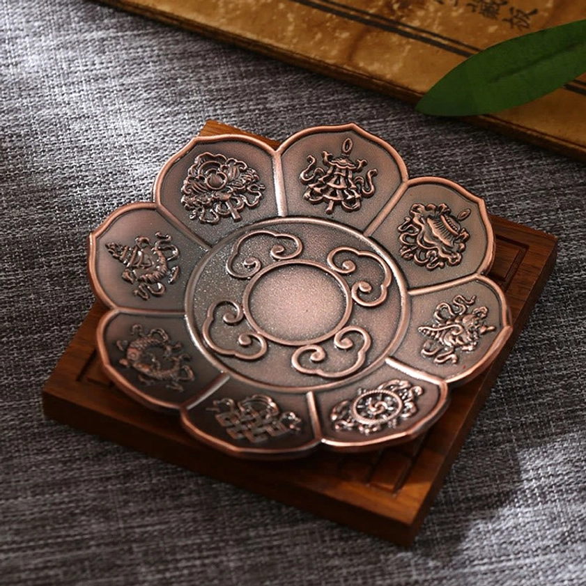 Eight auspicious symbols Buddhist incense holder in brown finish, overhead tabletop view with spiritual iconography