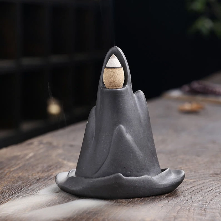Buddhist meditation incense holder close-up showing peak cone placement and mountain texture detail