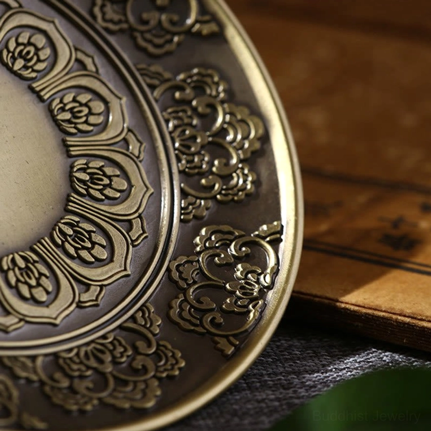 Close-up macro view of incense holder texture showing embossed cloud and floral motifs in bronze finish
