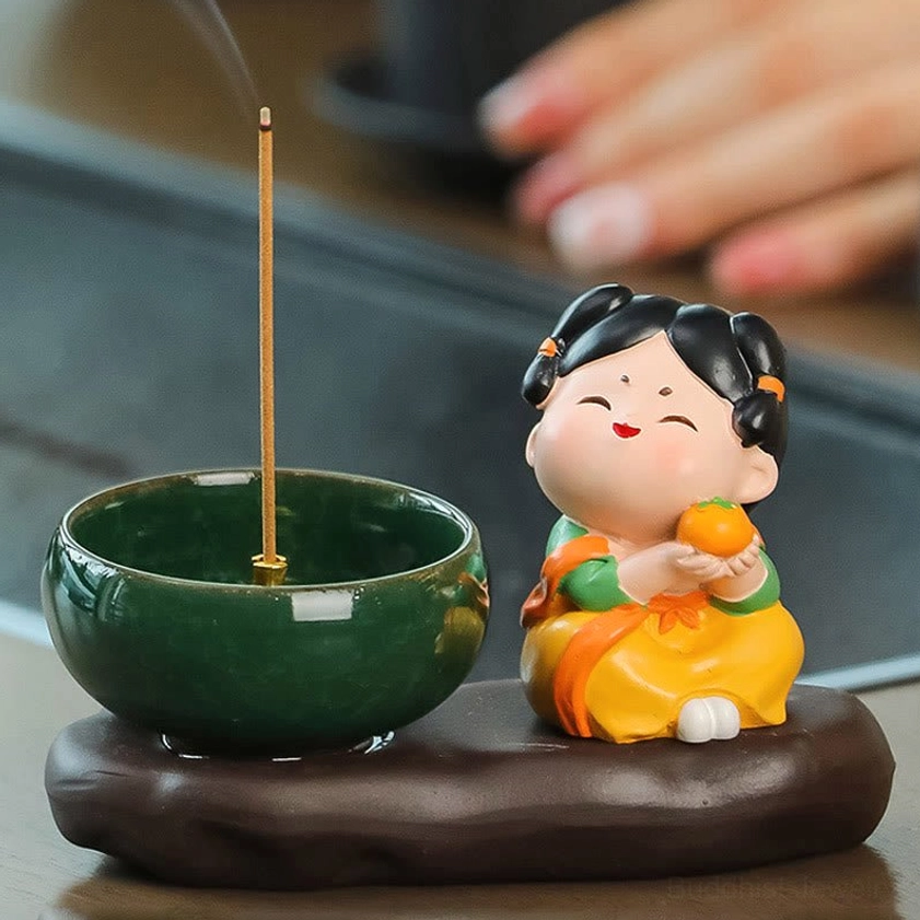 Ceramic incense burner from above showing burning incense with rising aromatic smoke and glossy dark green bowl for meditation practice
