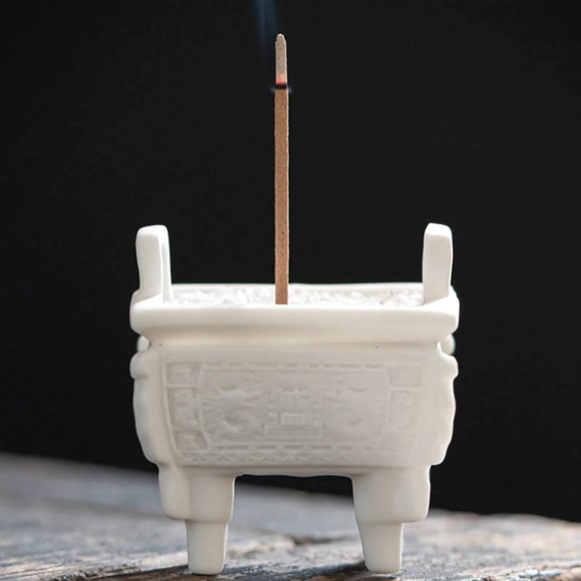 Buddhist ceramic incense burner with double lion ears and carved decorative patterns, front view showing four support legs and upright lugs