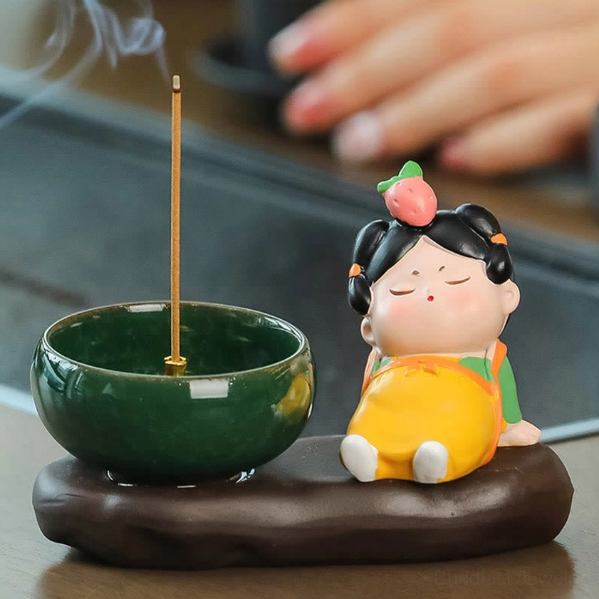 Buddhist ceramic incense burner with lady figurine featuring peach hair ornament, strawberry style motif, burning incense stick with brown base