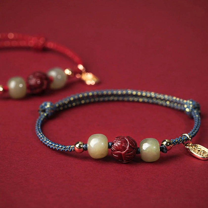 Two stacked Buddhist bracelets in contrasting colors with Hetian jade and cinnabar lotus beads, angled close-up showing handmade artisan details and quality