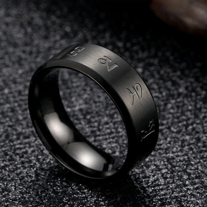 Side perspective of black Jambhala titanium steel ring, showcasing rounded band profile and hand-engraved mantras