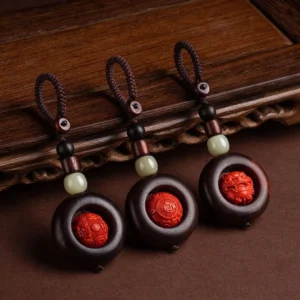 Buddhist protection keychains collection displayed on dark wood, featuring red sandalwood, cinnabar beads, jade stones, and copper coins with Om Mani Padme Hum symbols