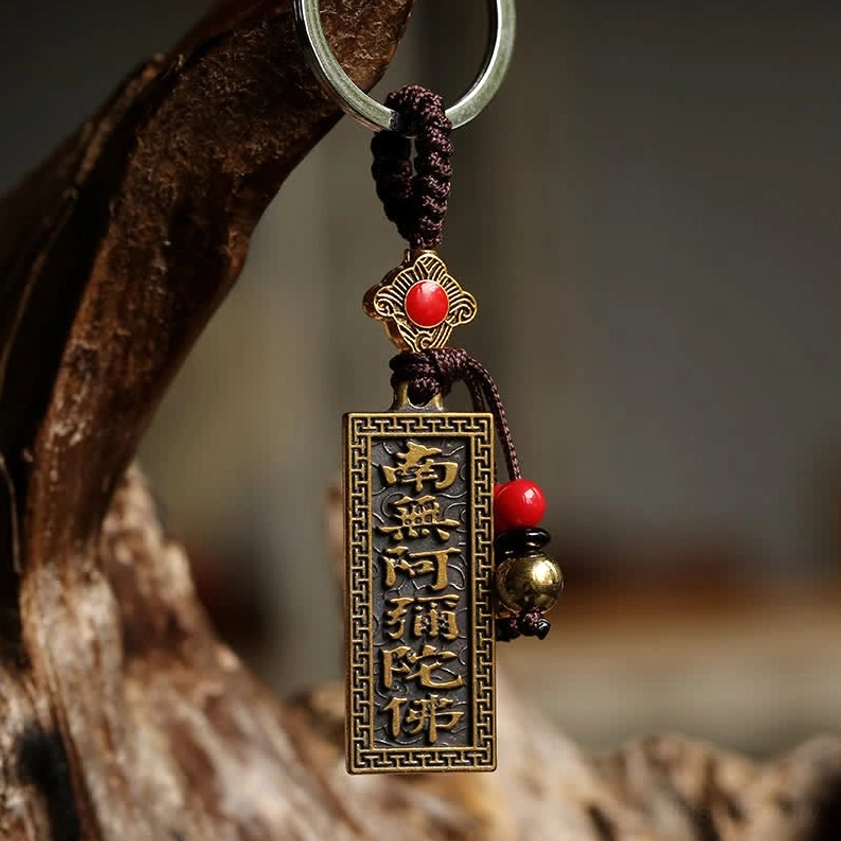 Side view of Buddhist blessing keychain featuring Namo Amitabha bronze tag with red enamel decoration and brass bells