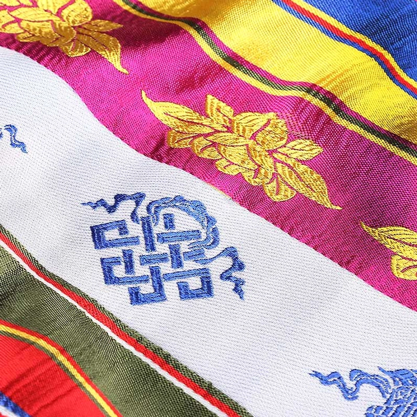 Golden lotus and endless knot embroidery detail on multicolored Buddhist Khata ceremonial scarf