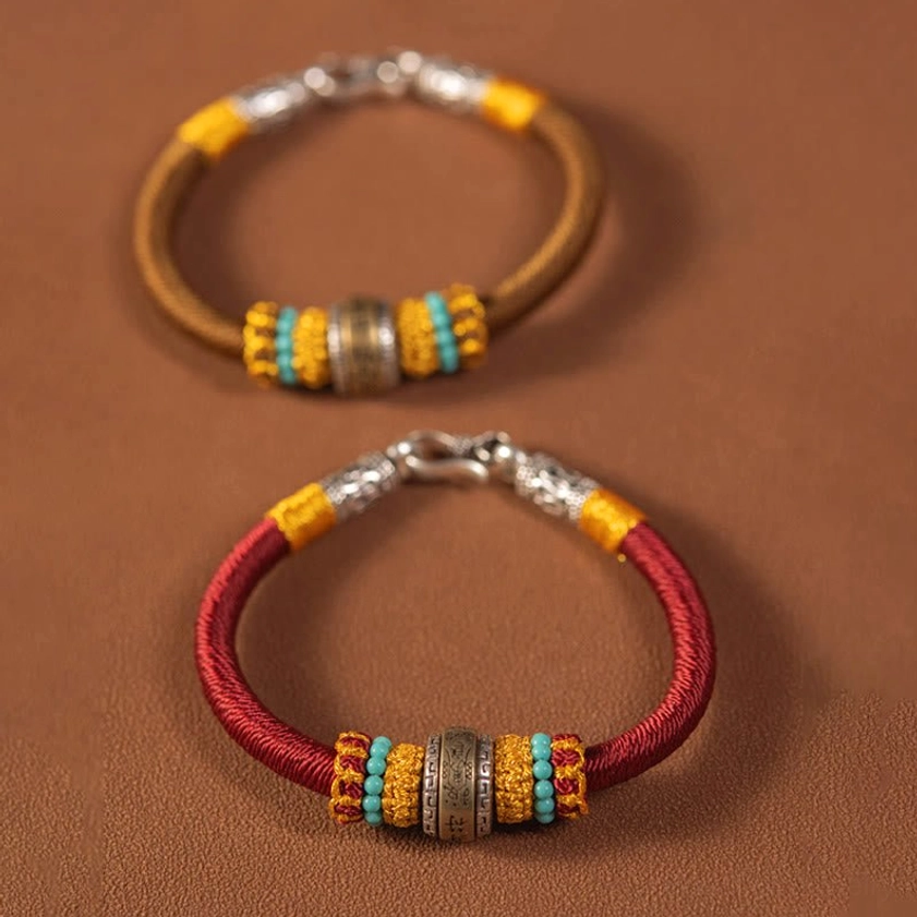 Pair of handmade Buddhist amulet bracelets in red and brown with identical metal charms and beaded accents