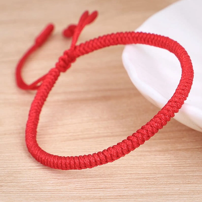 Buddhist king kong knot red string bracelet flat lay display showing woven texture and spiritual protection design
