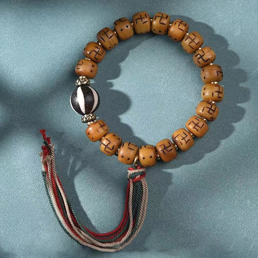 Buddhist camel bone prayer bracelet with sacred Kirtimukha charm, protective symbols, and handwoven tassel