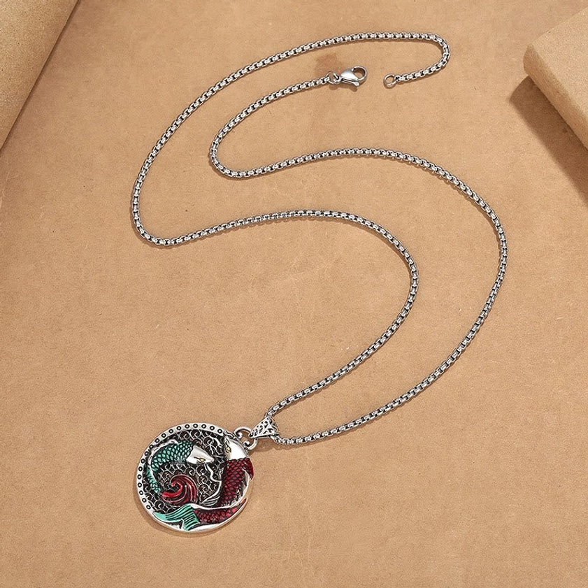 Loose copper koi pendant with silver wheat chain on kraft paper showing Buddhist fish symbolism