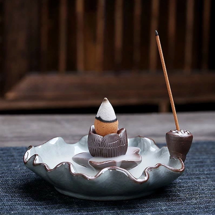 Lotus ceramic incense burner three-quarter angle with pale blue ruffled tray and backflow incense cone