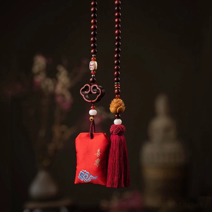 Twin Buddhist lotus car hanging sachets with wooden lotus charms, red tassels, and embroidered Chinese blessings displayed on dark vintage background