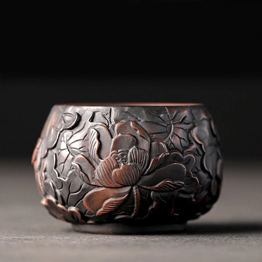 Handcrafted ceramic kung fu tea cup with embossed lotus floral patterns and brown finish, close-up front view