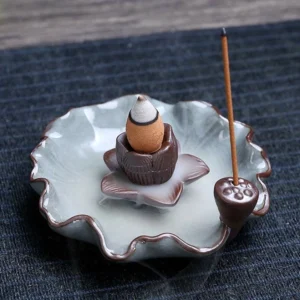 Lotus-themed ceramic backflow incense burner with brown crackle glaze, showing flowing smoke cascade on wooden table
