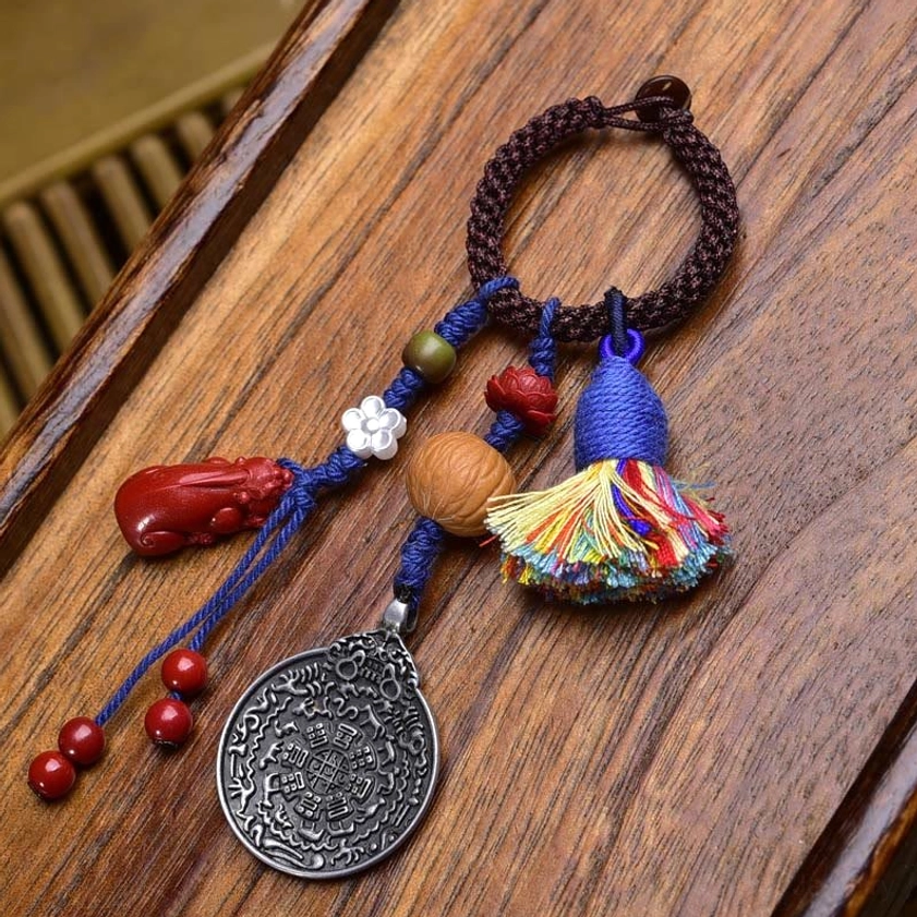 Lotus-style Buddhist amulet keychain with dark brown rope, turquoise accents, and hand-carved lotus charm