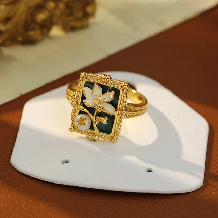 Vintage lotus ring on white display board - complete square enamel plaque with gilded lotus and pearl setting