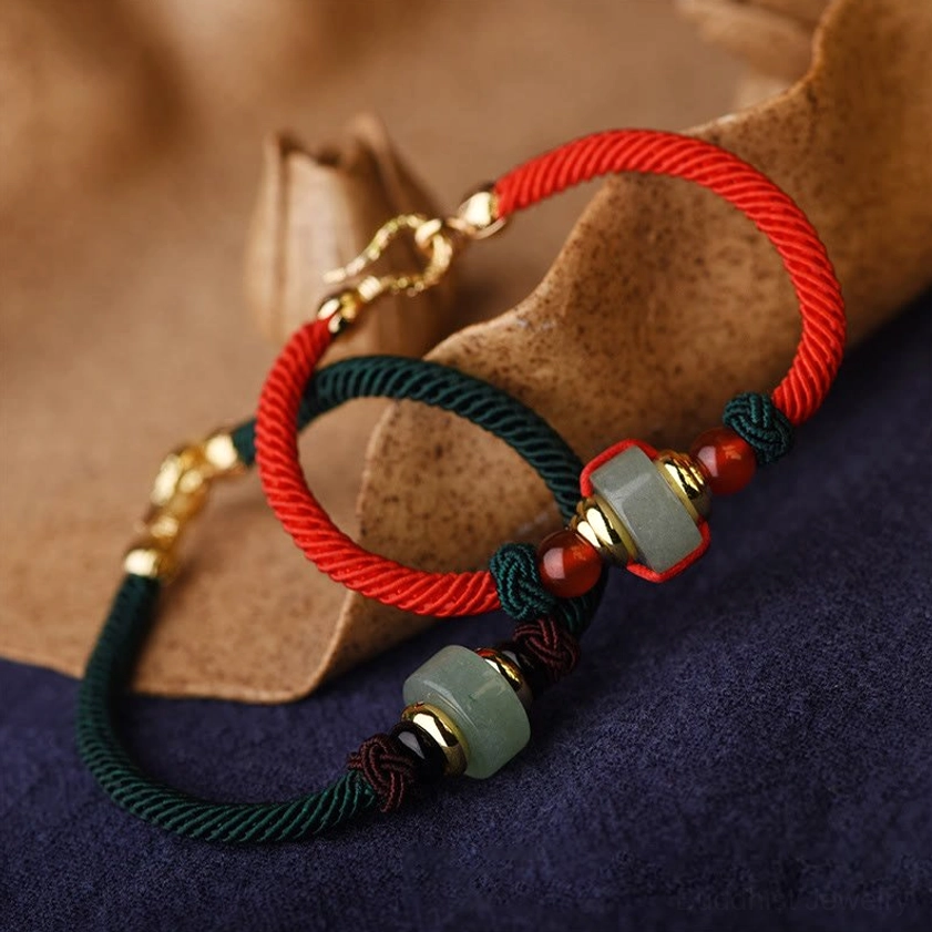 Close-up of handcrafted Buddhist string bracelet showing jade-style aventurine beads, red agate accents, and gold lobster clasp