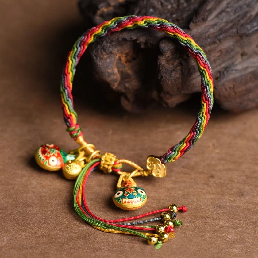 Buddhist rainbow braided luck bracelet featuring gold swallowing beast pendant charm with protective red string design