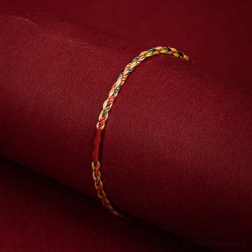 Buddhist red string bracelet detail showing twisted colorful strands and braided rope design