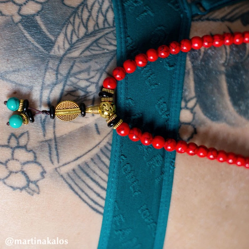 Prayer mala beads close-up showing red turquoise, turquoise spacers, and bronze metal components