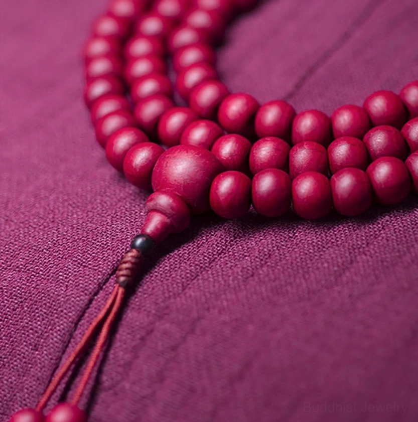 Buddhist prayer mala bracelet with 108 beads, guru bead, and decorative tassel displayed in top-down view