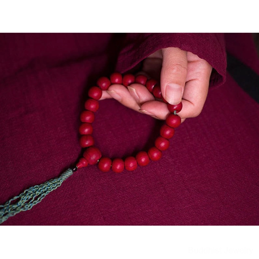 Circular Buddhist wrist mala bracelet overhead view held in two hands demonstrating proper use