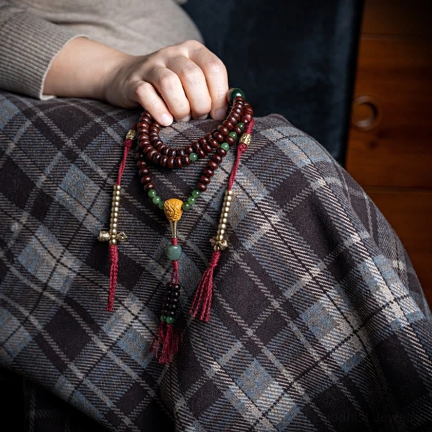 Buddhist 108 mala beads showing copper dorje symbol of spiritual strength and wisdom