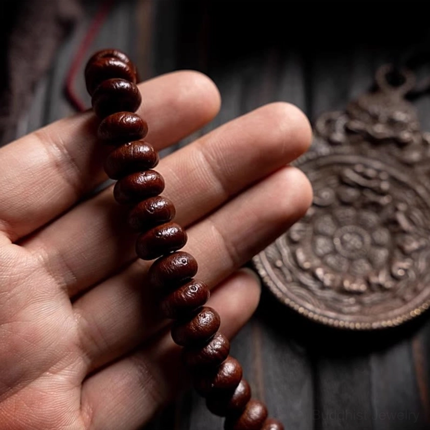 Buddhist mala beads with detailed view of red tassel guru bead and closure design
