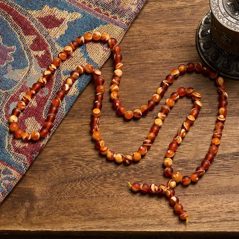 Warm reddish-orange amber prayer mala necklace with uniform round beads and tassel