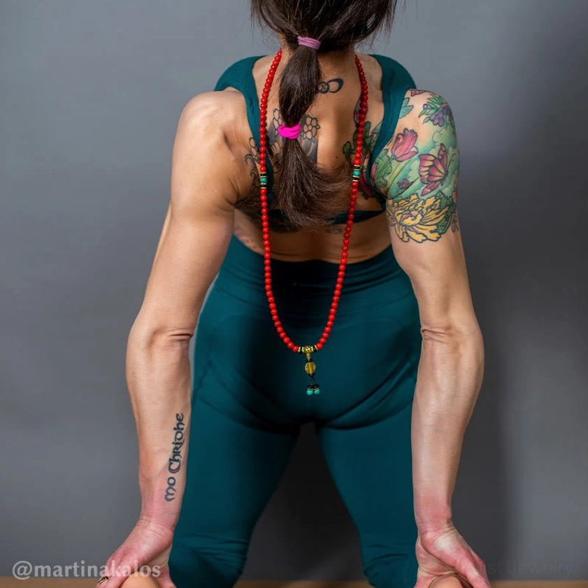 Wearable Buddhist mala necklace draped over back with red turquoise beads and matching tassel