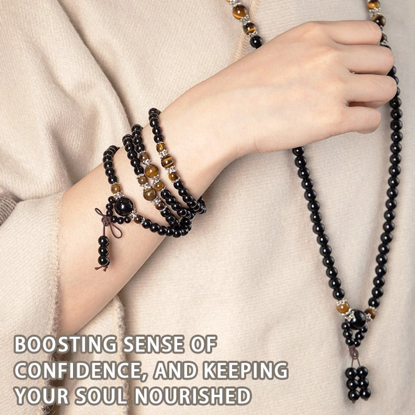 Layered Buddhist mala bracelets and long prayer necklace worn on hands against beige clothing with confidence and soul nourishment theme
