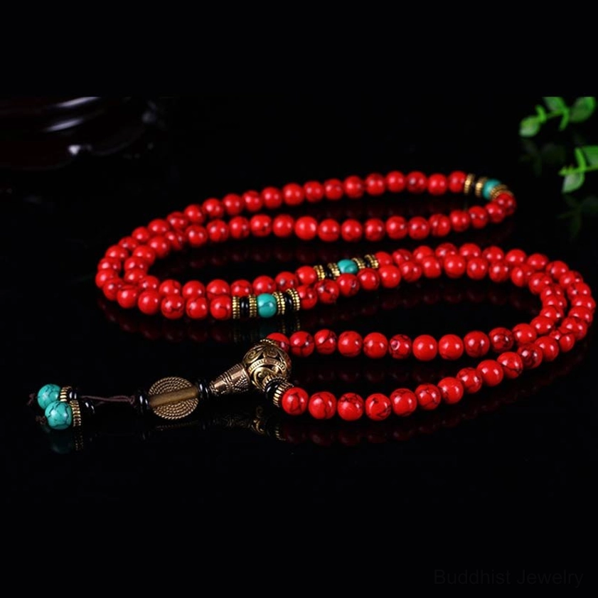 Double-strand Buddhist mala bracelet with red turquoise and turquoise pendants, flat lay styling