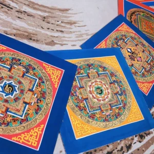 Handmade Buddhist mandala thangka painting with intricate geometric religious motifs and colorful decorative borders displayed on wooden surface