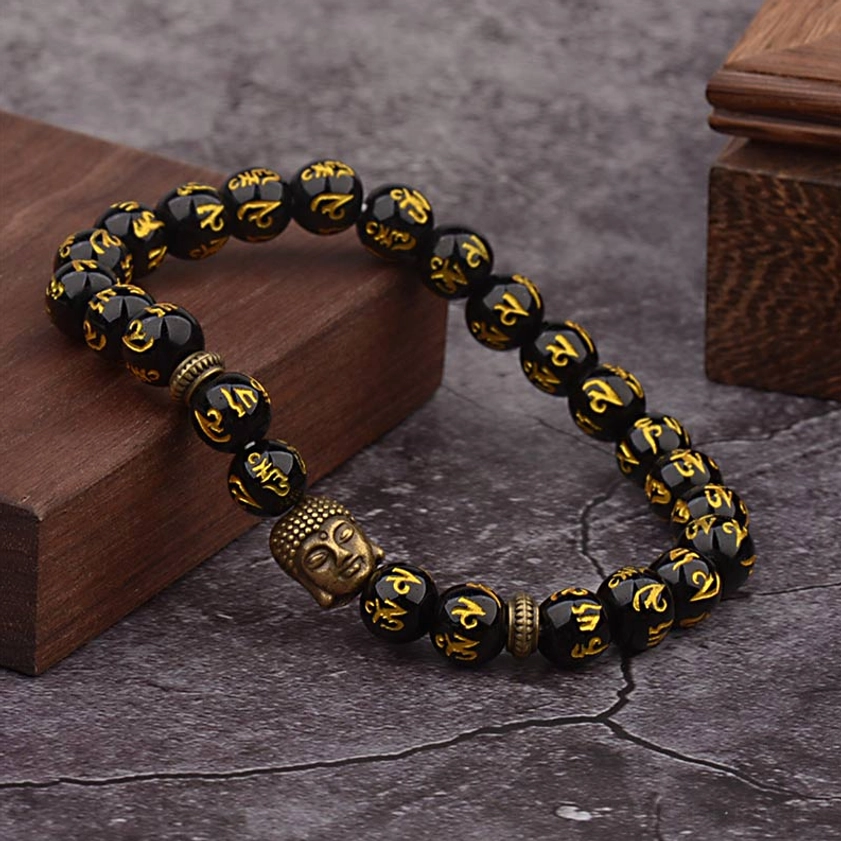 Buddhist black agate bracelet featuring Six True Words Sanskrit text and bronze Buddha charm, angled product shot