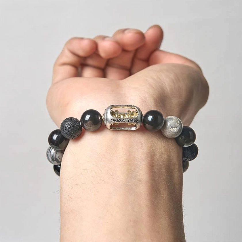 Buddhist mantra bracelet fitted on hand showing stone texture and metal charm detail